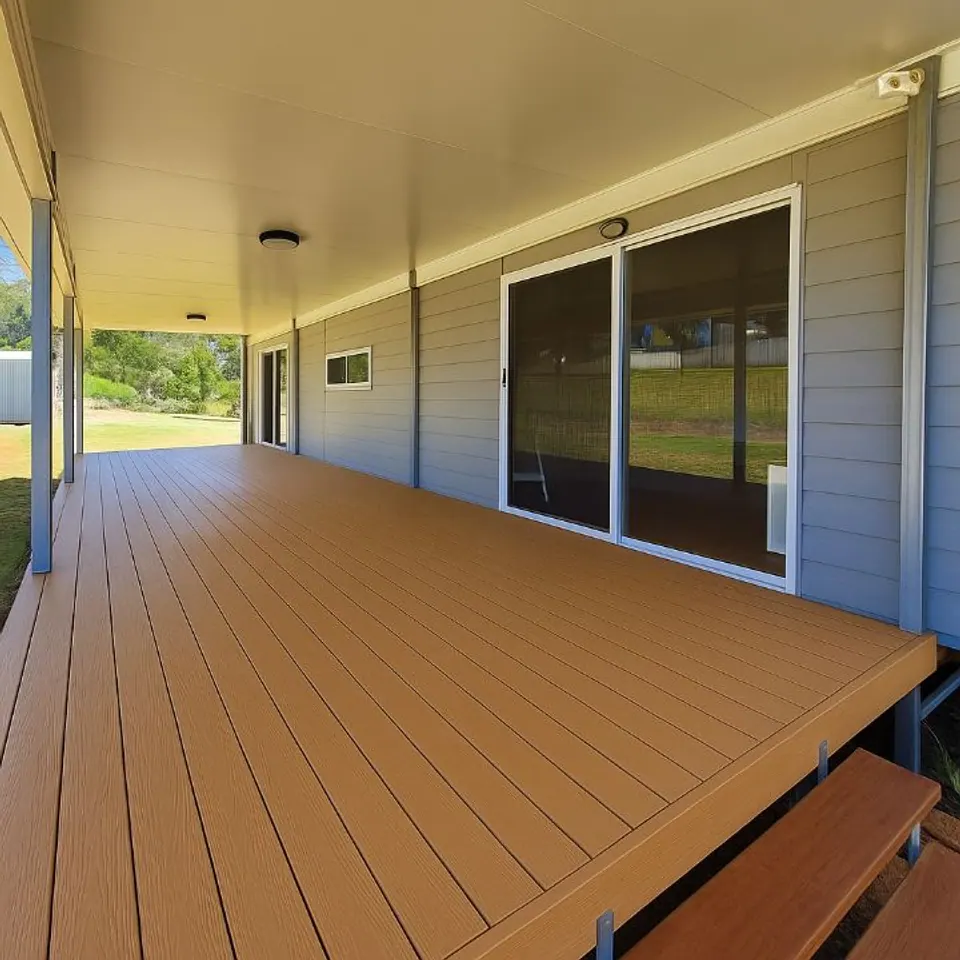 Roomi covered deck project, with decking, roof and steps shown. The adjacent Joiner building is separate; size and inclusions vary by design.